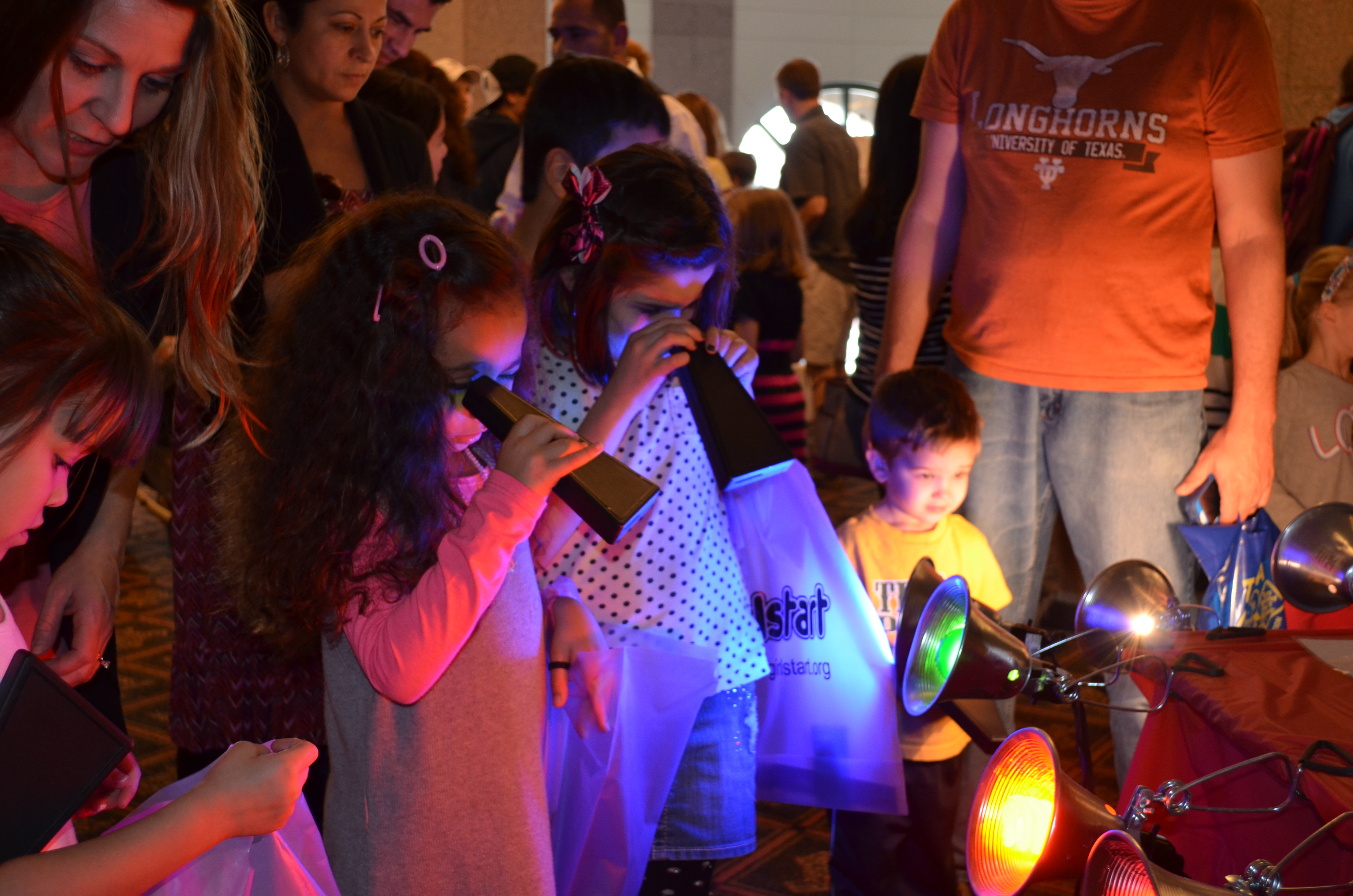Young visitors explore the spectrum of different light sources with spectroscopes at the Bullock Museum's annual WeatherFest event.