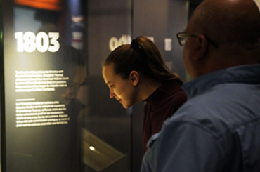 Two people looking at an exhibit at the Bullock Museum.