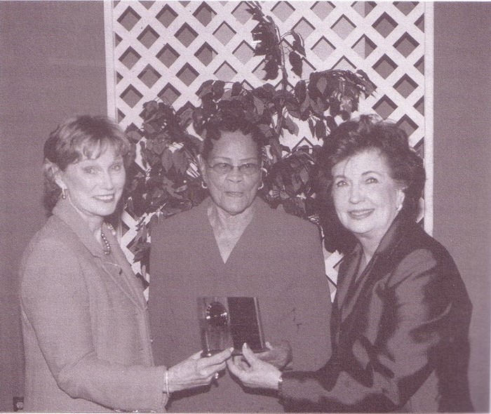 Birdie Wade (center) receiving an award for excellence.