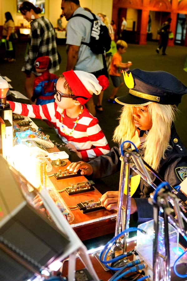Children dressed in costumes and doing a science activity at the Bullock Museum.