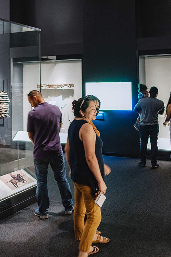 adults looking at artifacts on display in the Bullock Museum