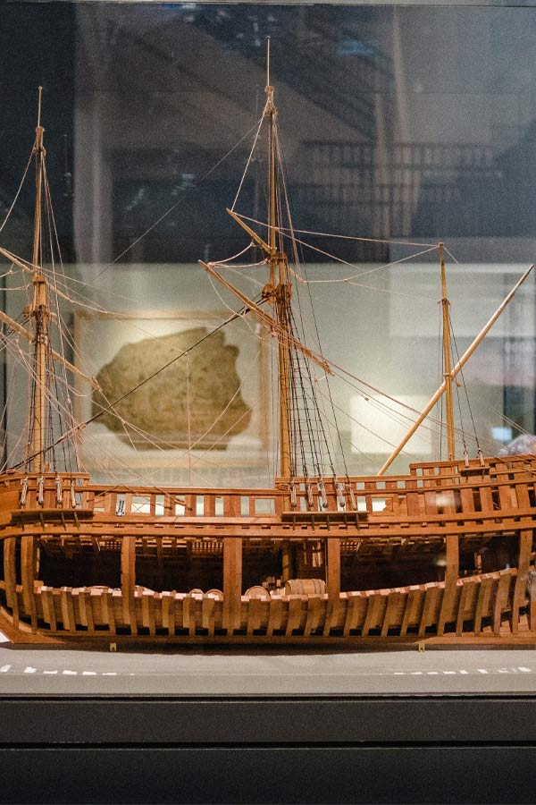 wooden model of the ship La Belle with the cargo section open showing barrels and rope