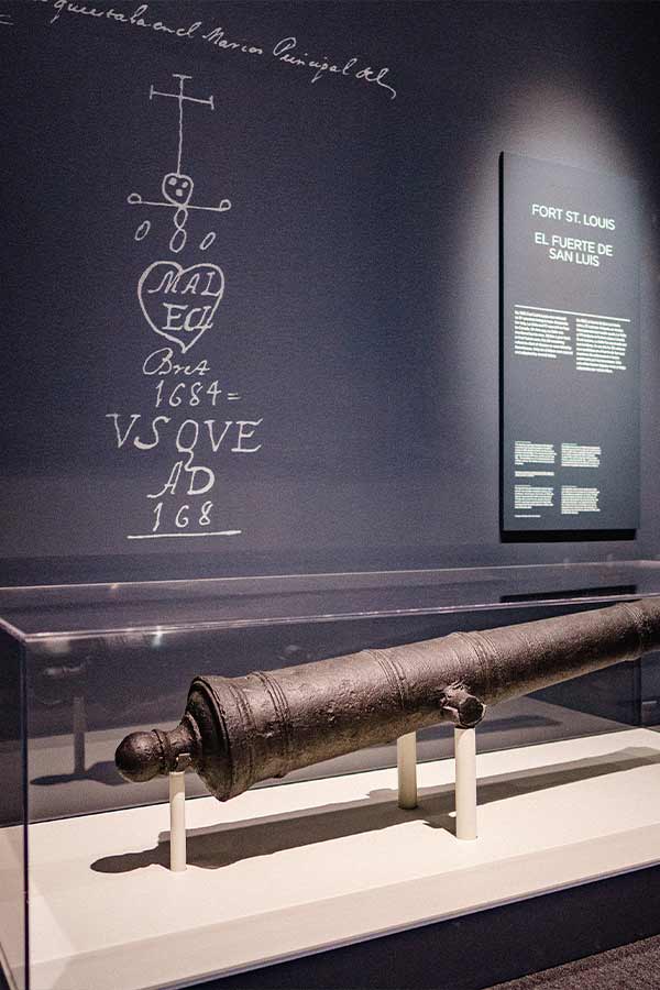 bronze cannon in a display case in the Bullock Museum