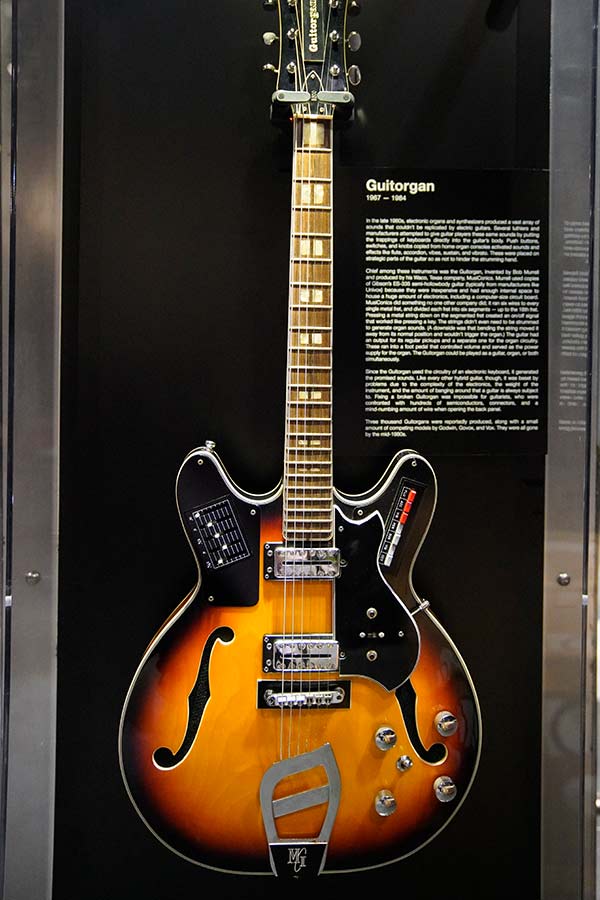 wooden guitar in a display case in the Bullock Museum exhibition 