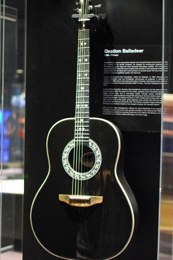 black acoustic guitar in a display case in the Guitar exhibition
