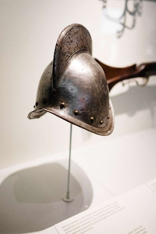Silver European military helmet on display in a museum