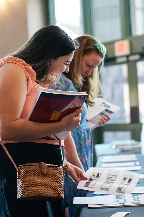 two women holding papers and looking at educational resources in the Bullock Museum