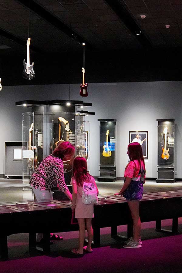 family standing around the World's Largest Guitar in the Bullock Museum
