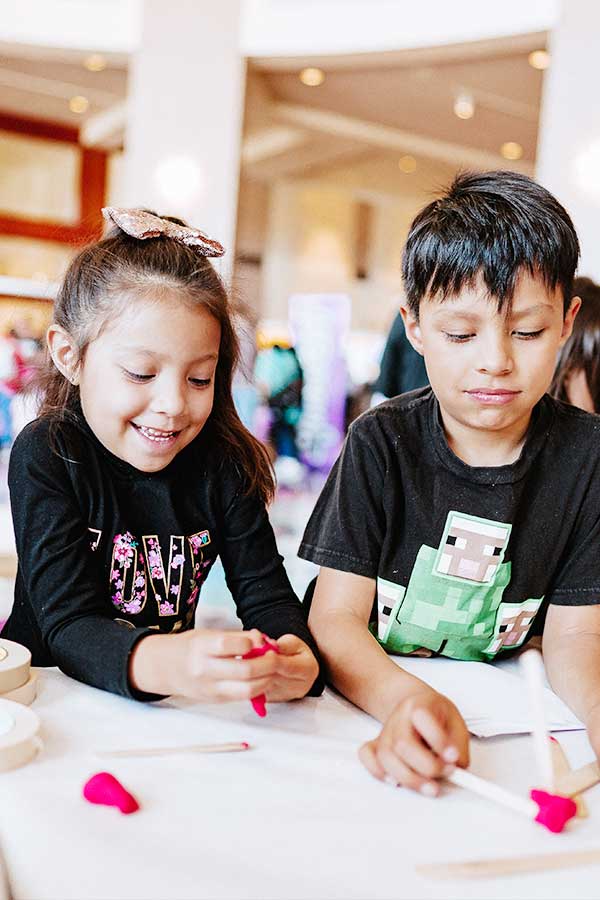 two young children standing at a craft table at the Bullock Museum