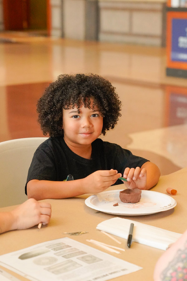 A child doing a clay pot craft at the Bullock Museum.