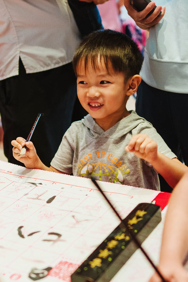 A child and caregiver doing an Asian calligraphy craft.