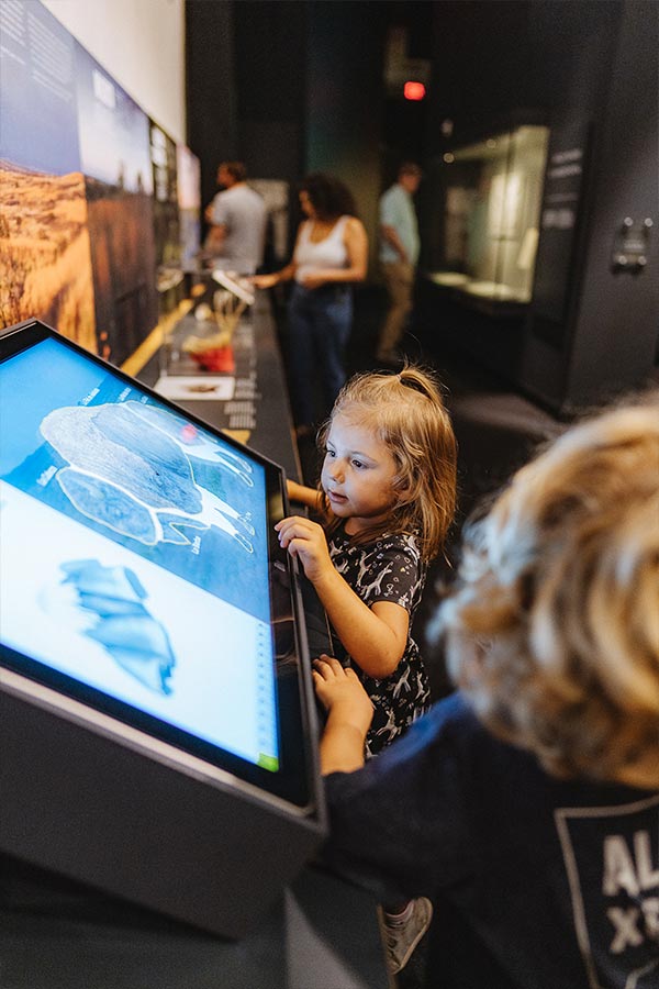 a young girl playing with a digital interactive in the Bullock Museum