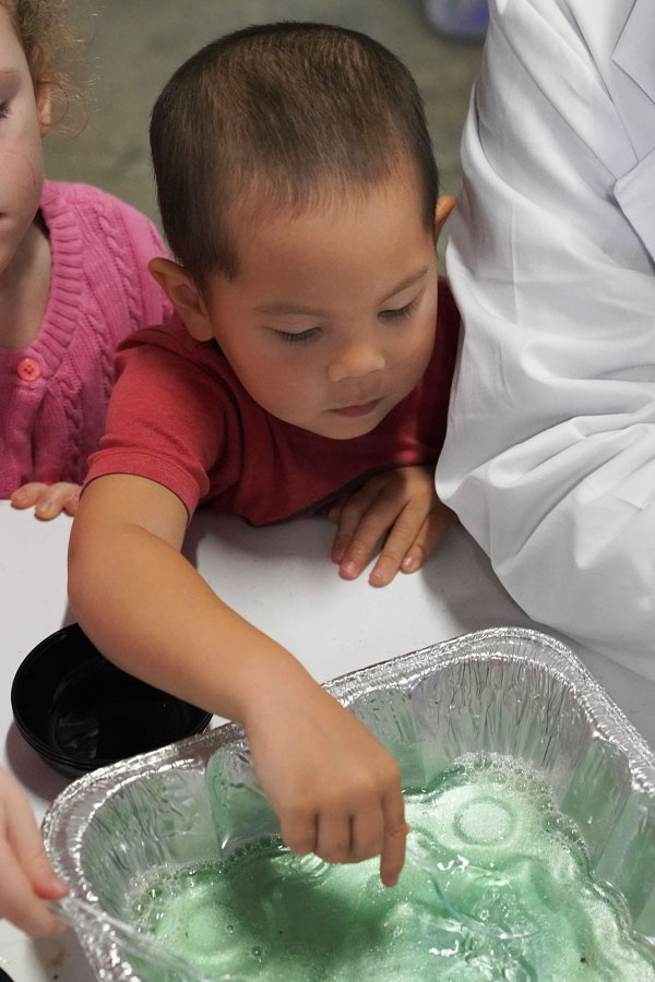 children doing a water tray activity at the Bullock Museum.