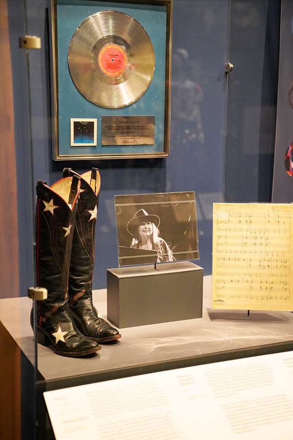 Bobbie Nelson's black cowboy boots, gold record, and photograph on display at the Bullock Museum