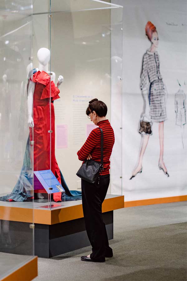 Woman looking at fashion piece in Fahsion Forward exhibit