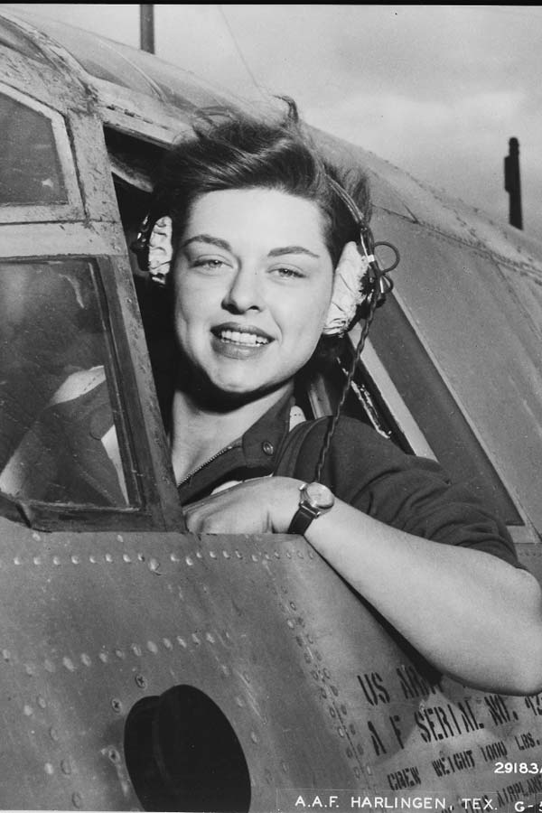 black and white photo of a Elizabeth Gardner in a WWII US Army plane sticking her head out of the cockpit window