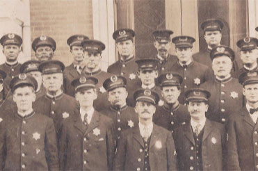 sepia toned photo of a group of police officers standing in rows