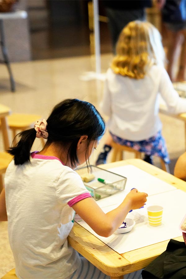 young girl sitting at a table in the Bullock Museum painting