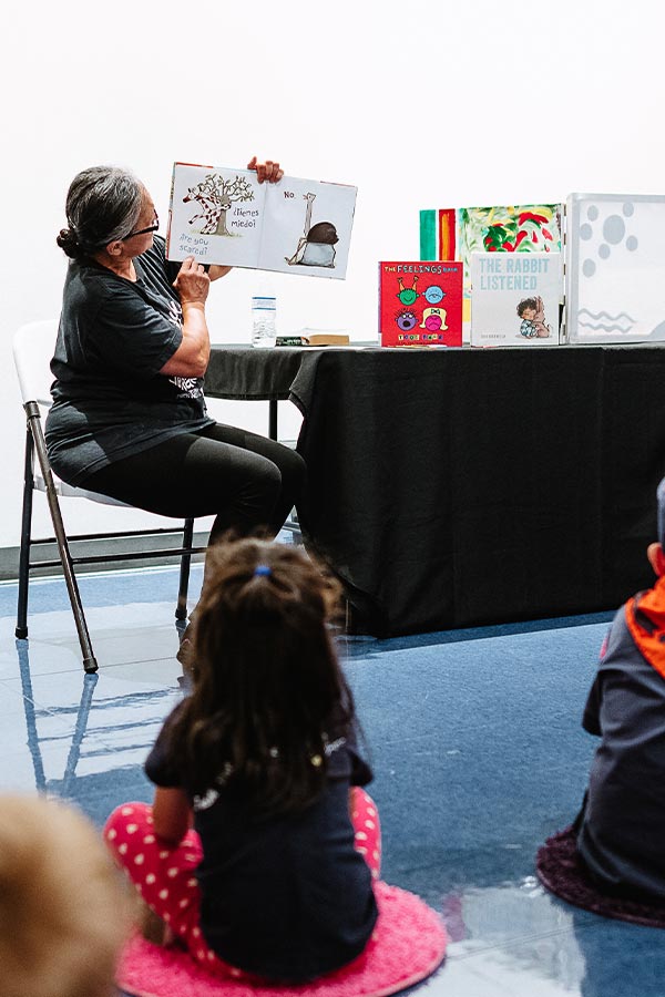 a woman reading a book to a group of young children in the Bullock Museum