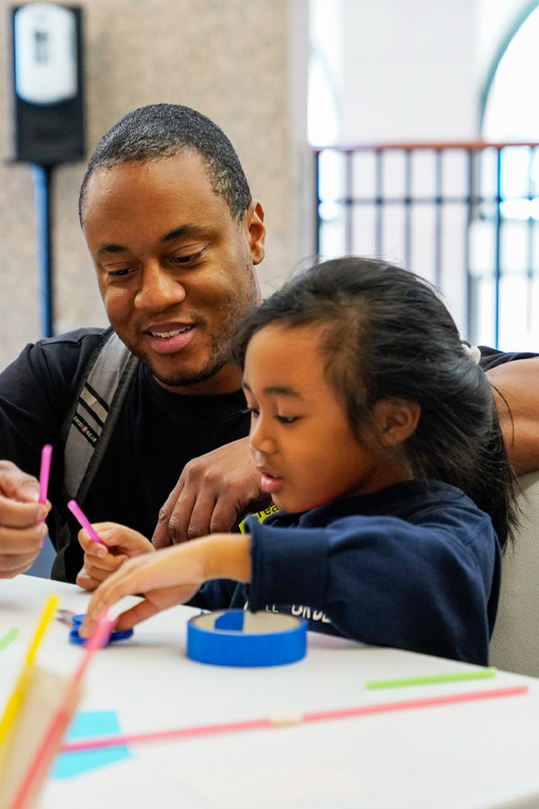 A child and their caregiver doing a craft together.