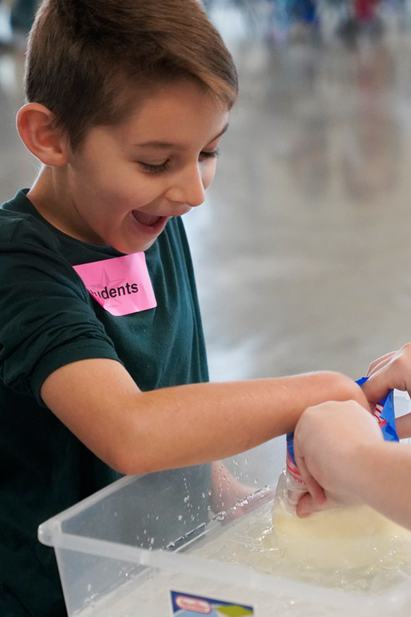 a young boy participating in a water science craft activity