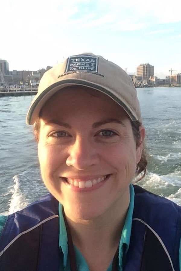 Lindsey Savage smiling into the camera on a boat in water