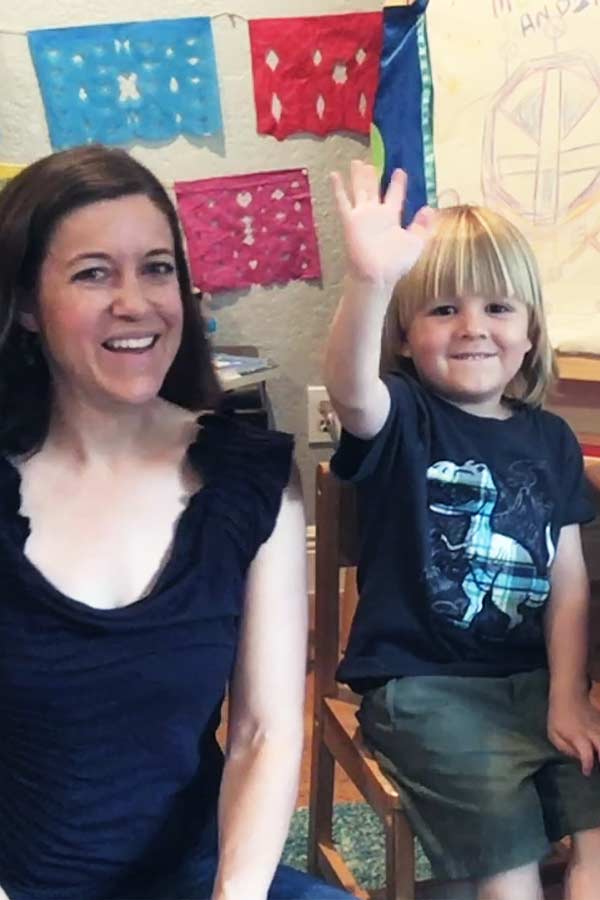 Museum Educator and her child waving to the camera during an online LIttle Texans program