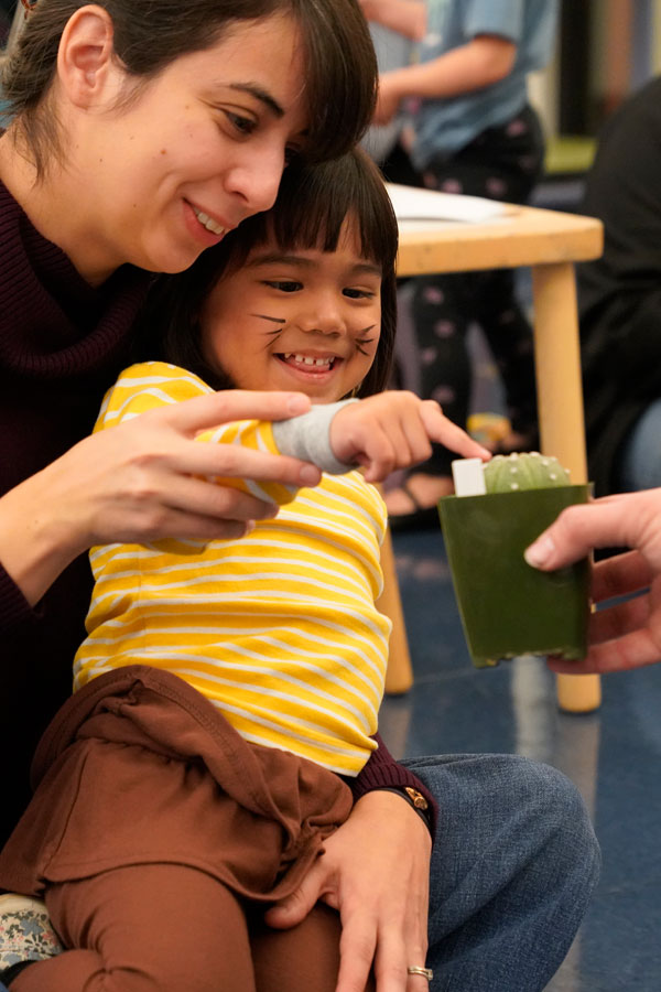 a young girl and her mom touching a cactus