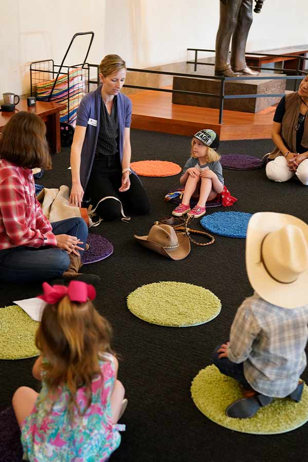 children sitting on colorful circles with Bullock Museum educators