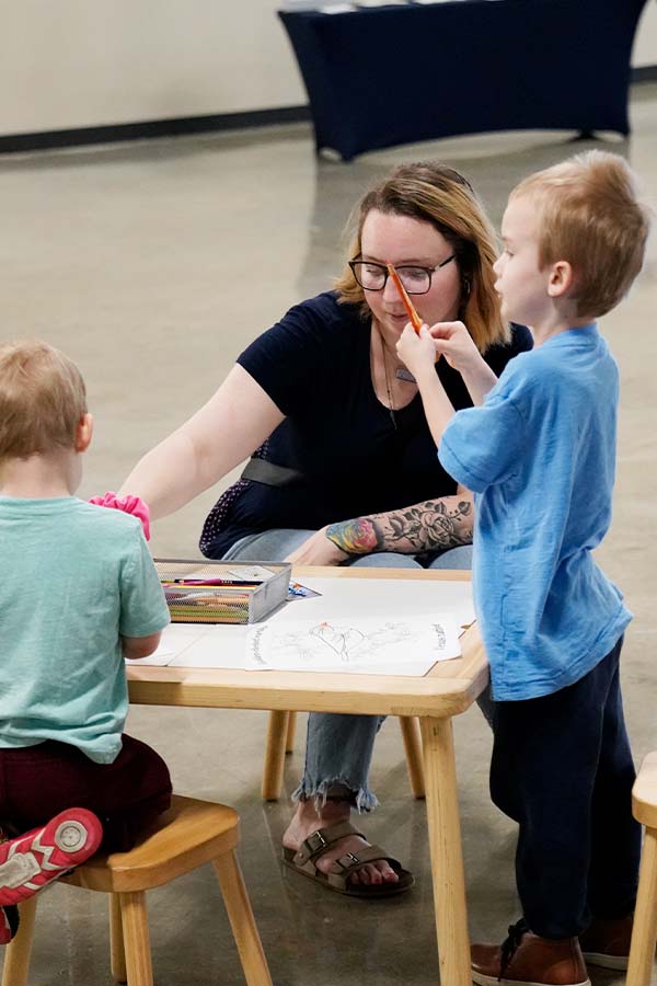 two children and a woman at a table doing a craft at the Bullock Museum