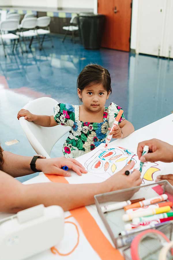 a young girl holding a marker doing a craft activity