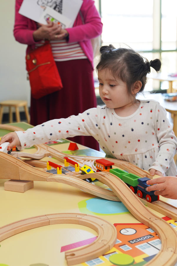 a young child playing with a train set.