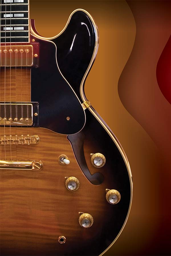 close up of a brown, wooden electric guitar against a red, orange, and yellow background
