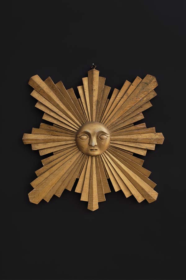 gold colored plaque in the shape of a sun
