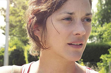 A woman in a pink tank top, Marion Cotillard, looks into the distance