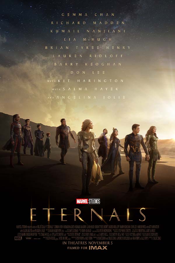 film poster of "Eternals" with characters from the film standing in sand dunes with a dark starry sky behind them