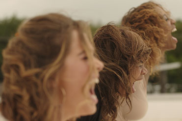 Profiles of three young women screaming