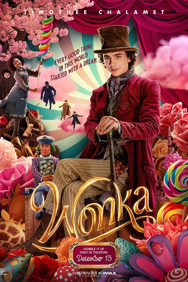 film poster for "Wonka" of Willy Wonka perched among pink flowers and candy holding his cane