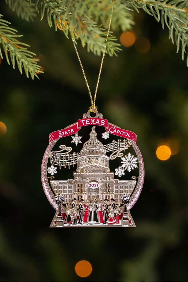 decorative ornament of the Texas State Capitol hanging on a green tree
