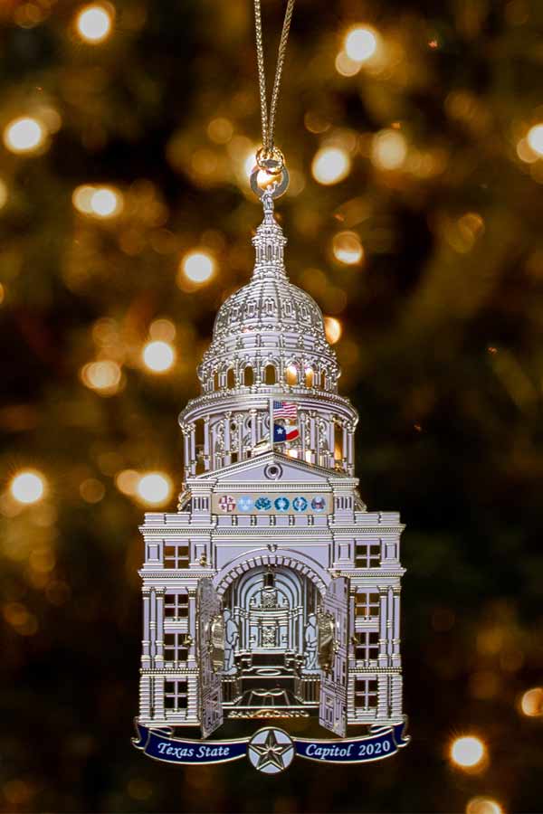 decorative ornament of the Texas State Capitol hanging on a green tree