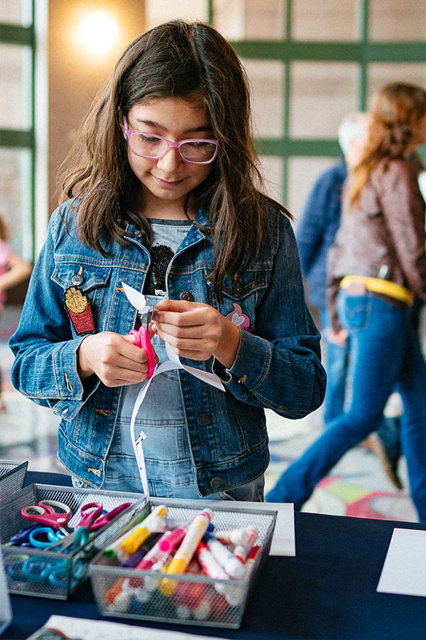 A girl uses scissors to cut creative paper