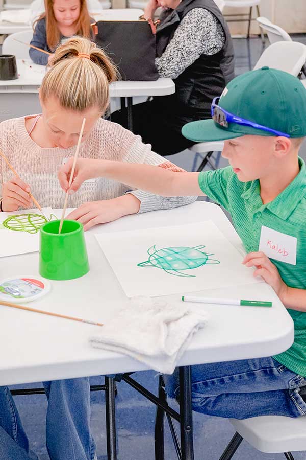 a boy and a girl sitting at a table doing watercolor at the Bullock Museum