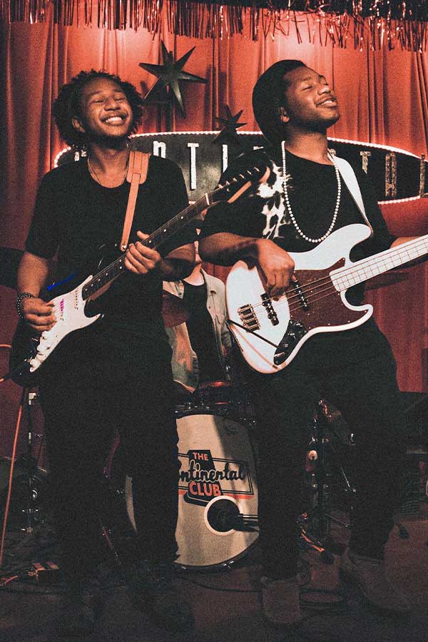 The Peterson Brothers, two Black men playing guitar on a stage