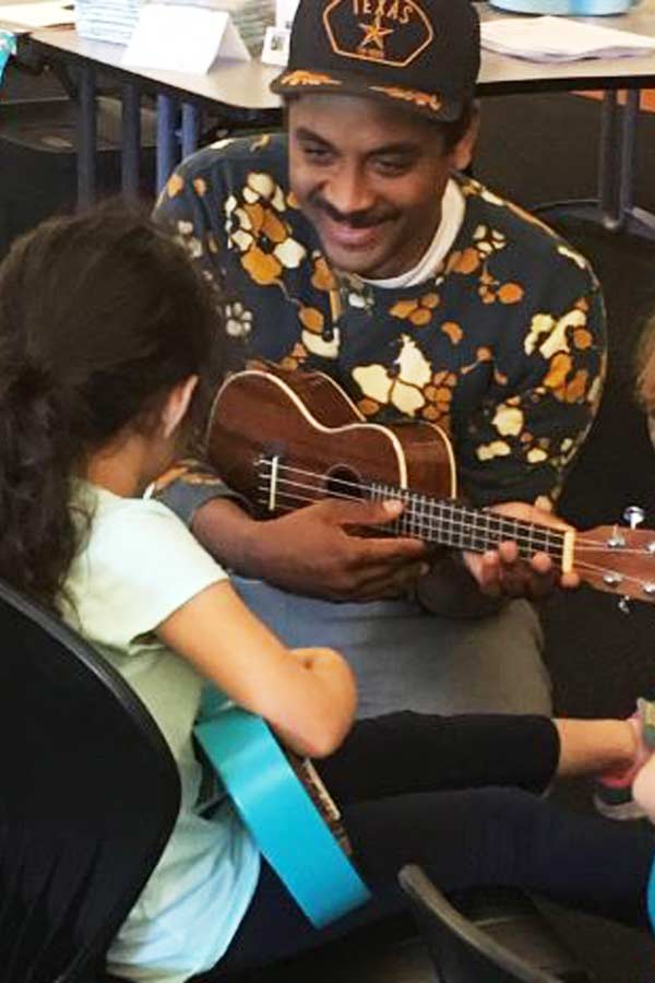 man facing a child playing guitars together in the Bullock Museum