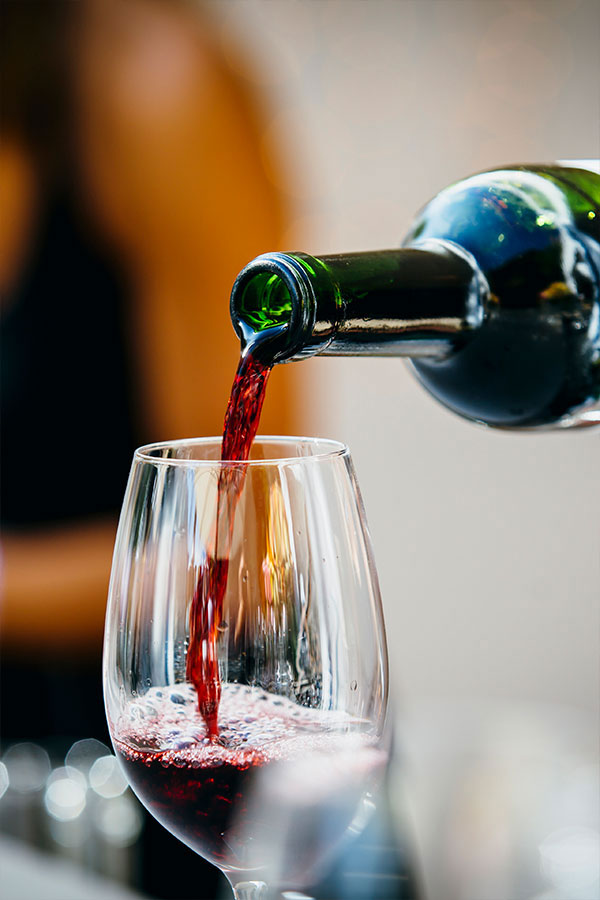 red wine being poured into a wine glass