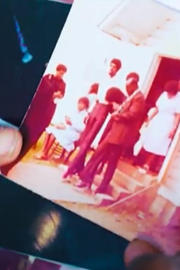 hand holding aged photograph of people walking down steps