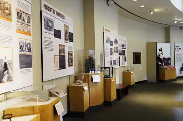 wooden pedestals with artifacts on them, wall graphics with text about the exhibit Black Citizenship in the Age of Jim Crow