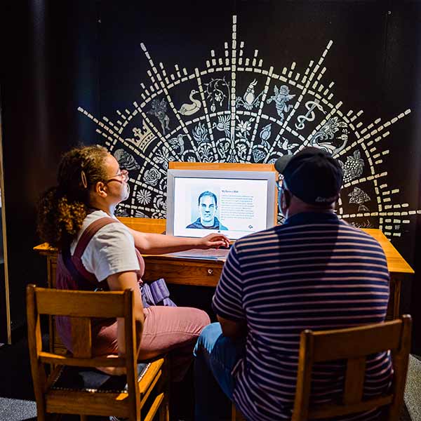 two people sitting at a table interacting with a computer in the Mind Matters exhibit