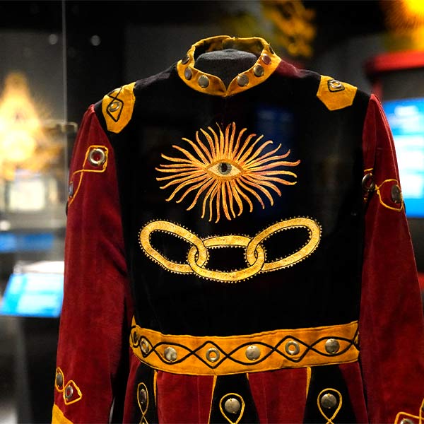 black, gold, and red Independent Order of Odd Fellows costume in a display case in the Bullock Museum