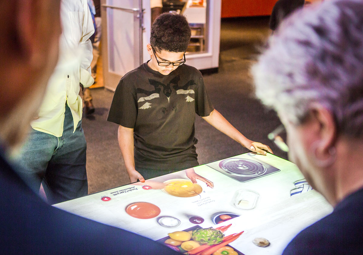 Visitors may take a turn at an interactive cooking table to make virtual dishes eaten around the world. The Our Global Kitchen: Food, Nature, Culture exhibition will be on view at the Bullock Museum through July 24, 2016.